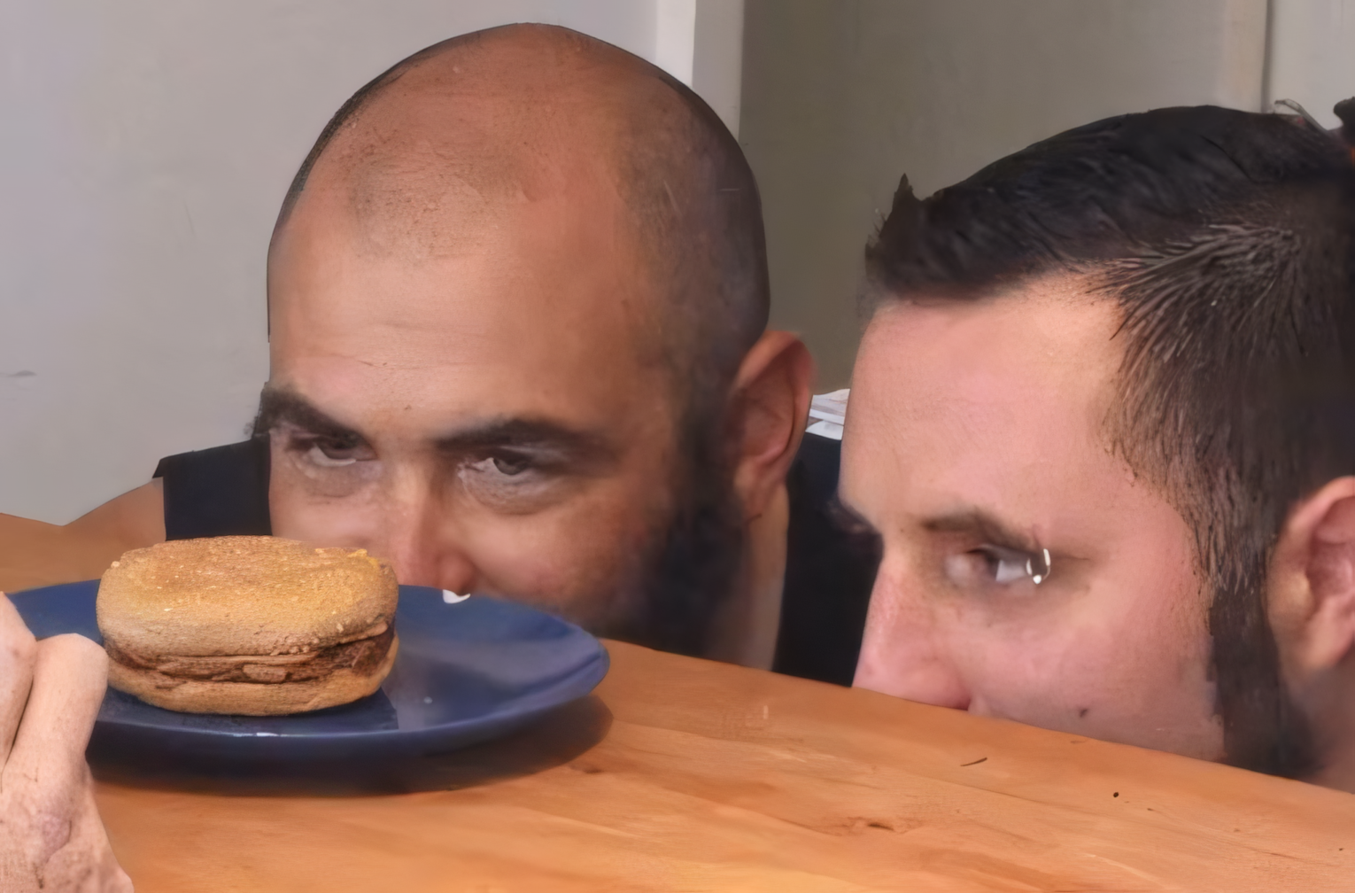 Casey and Ed peer over a table at Senior Burger on a blue plate.